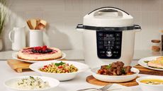 A white Instant Pot Pro Max with Wi-Fi in a modern white kitchen, surrounded by dishes