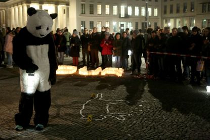An activist in a World Wildlife Fund (WWF) panda bear costume attends vigil in Germany