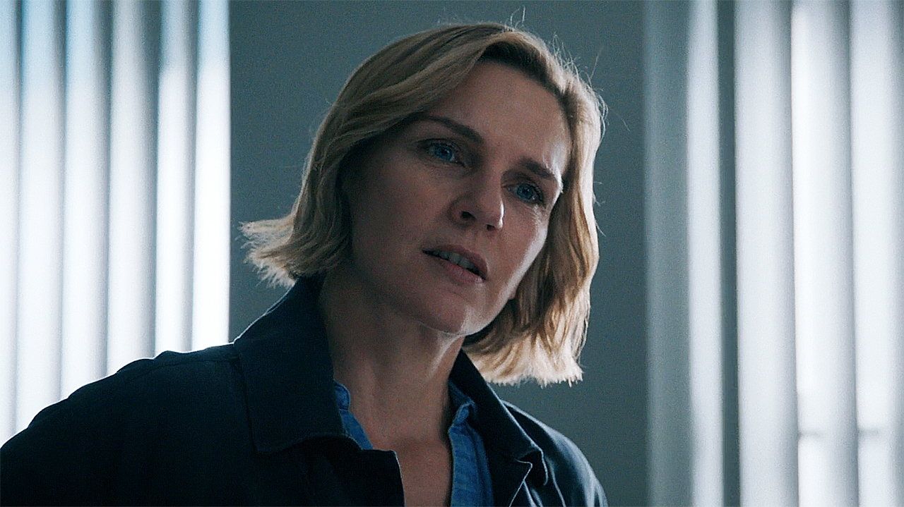 Carol standing up with her head tilted to the left in Pluribus episode 4