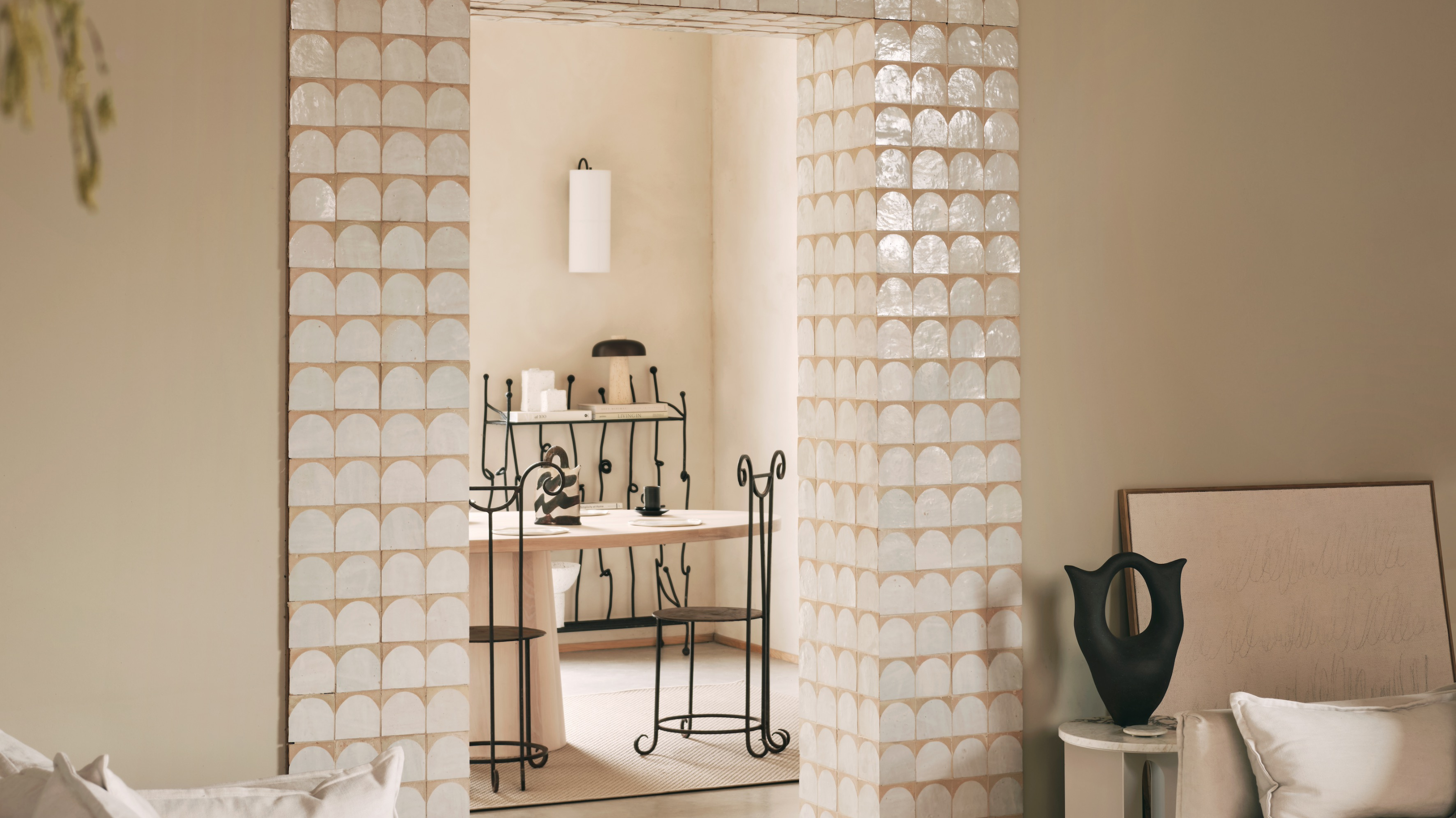large doorway trimmed with half moon zellige tiles in a large neutral toned room