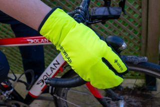 A cyclist wearing the Gore Trigger gloves holding a brake lever