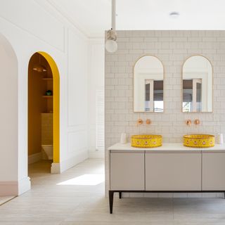 White bathroom with yellow basins and