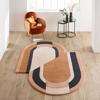 Oval geo design rug in brown, cream and green on a wood floor