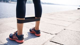 Close up of resistance band around runner's legs