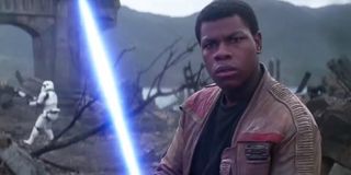 John Boyega holding a lightsaber