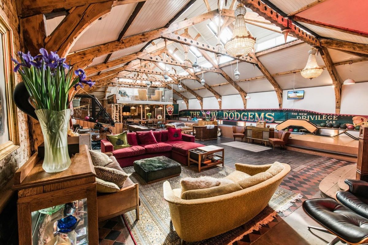The open plan living room shows 3 comfy sofas and an upstairs balcony