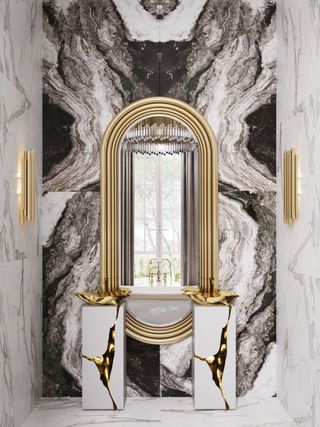 Marble bathroom with large gold mirror