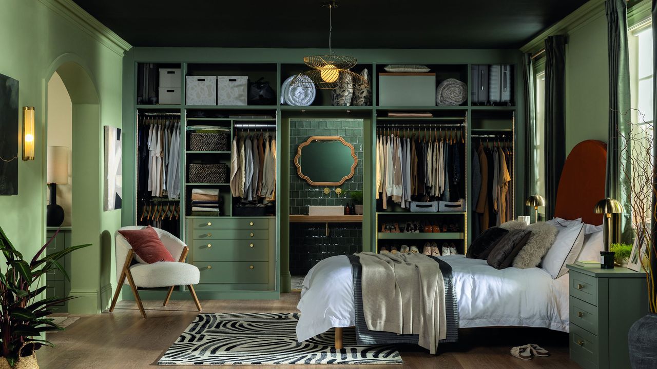 Green bedroom with wall to wall wardrobe of storage shelves and hanging rails