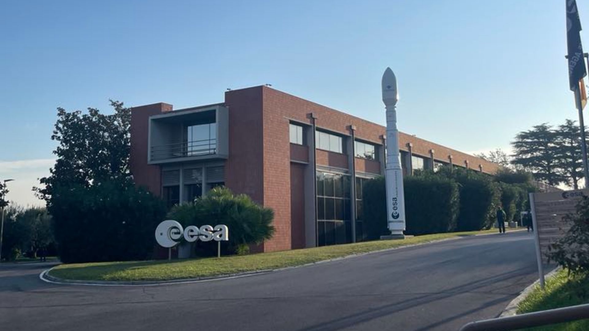 A photo of an ESA sign and model rocket at the entrance to the ESRIN center in Frascati