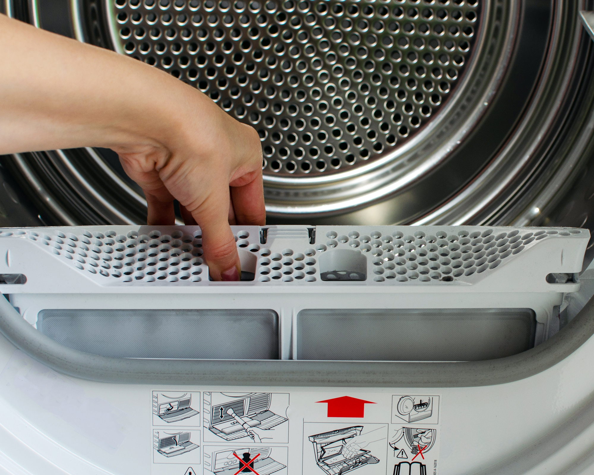 A woman's hand removing lint filter from the dryer