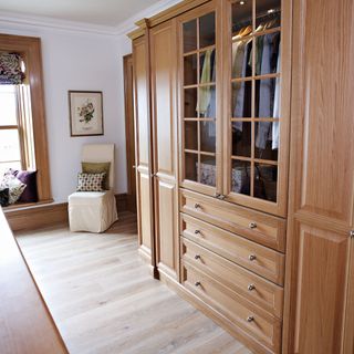 brown cabinet wooden flooring white walls and clothes
