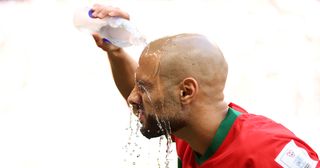 Sofyan Amrabat of Morocco pours water during the FIFA World Cup Qatar 2022 Group F match between Morocco and Croatia at Al Bayt Stadium on November 23, 2022 in Al Khor, Qatar.