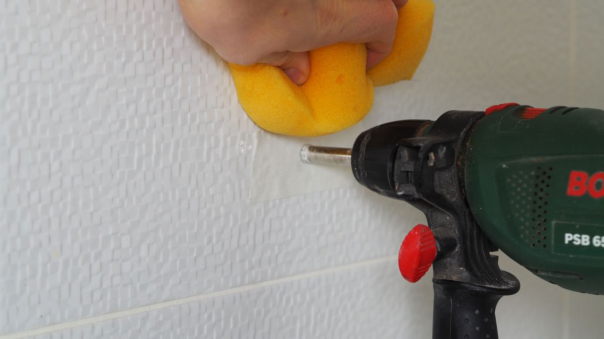 cooling down a tile drill bit with a wet sponge