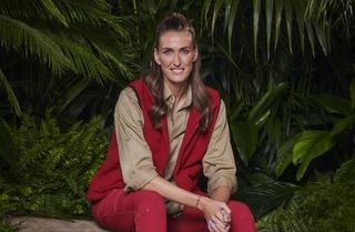 Jill Scott, I'm a Celebrity 2022 winner, in her camp clothes, sitting on a rock and smiling