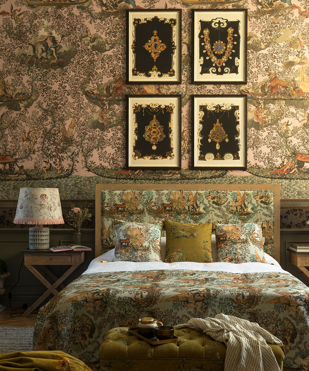 An archival bedroom with traditional scenic wallpaper behind a bed with an upholstered headboard