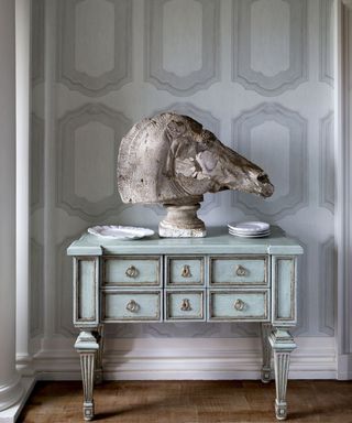 A grey wall panel effect wallpaper with duck egg blue console table and elephant decorative ornament