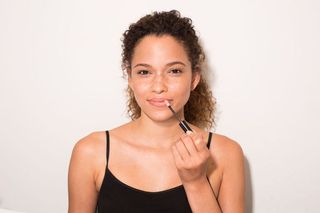 Model applying a high-shine lip gloss