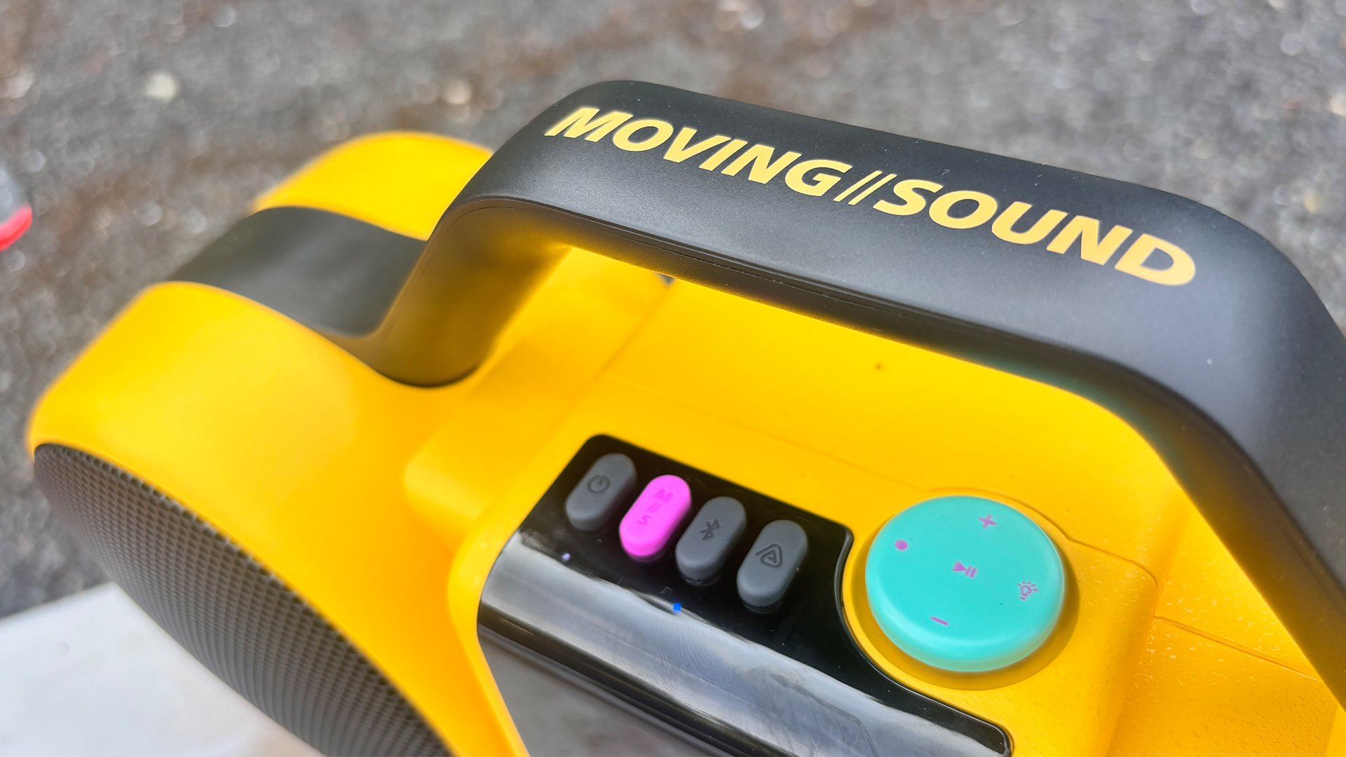 Philips The Roller wireless speaker close up on controls, handle and 'Moving Sound' logo