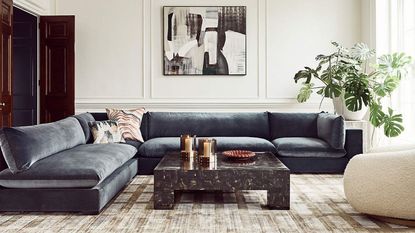 living room with gray velvet sofa and marble coffee table