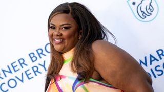 Nicole Byer smiling on a red carpet