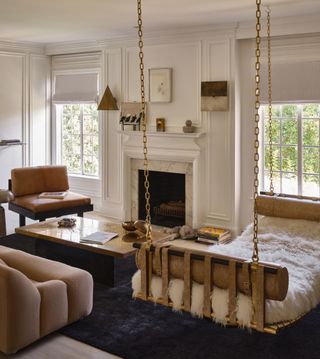 A swing seat in a neutral living room with a dark rug and brown leather chair