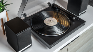 Victrola Automatic turntable on desk with speakers