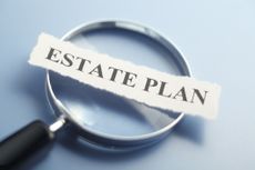 paper that says "estate plan" on magnifying glass