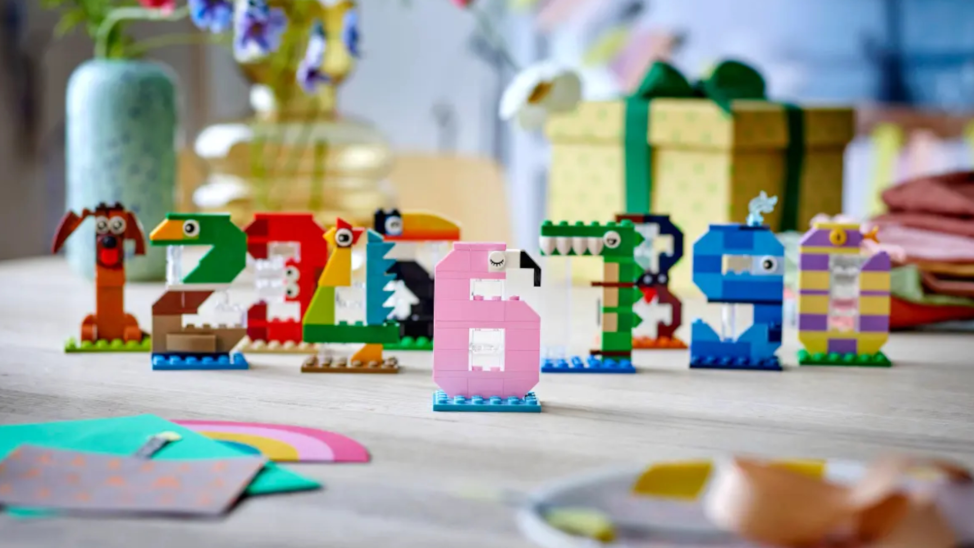 Lego Birthday Numbers laid out on a table in front of a wrapped present box