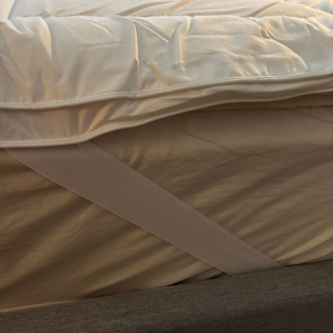 Mattress topper on a mattress on a grey bed