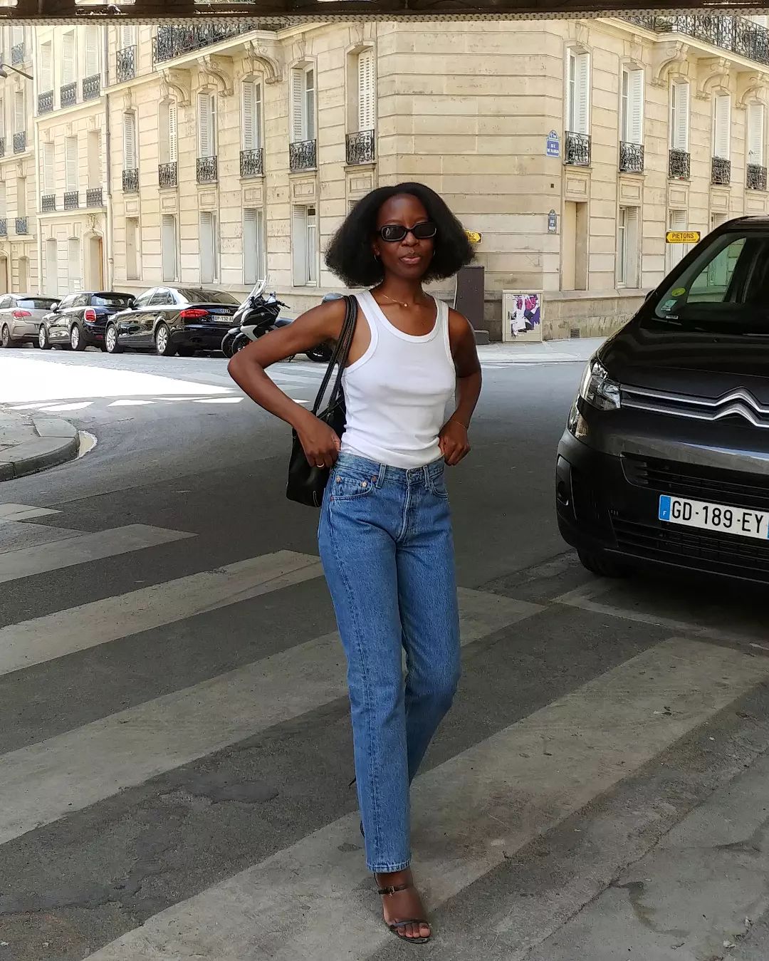 Slyvie Mus in white tank top and jeans