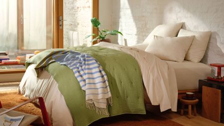 Brooklinen Airweave Quilt in Fern pictured on a bed in a sunny room