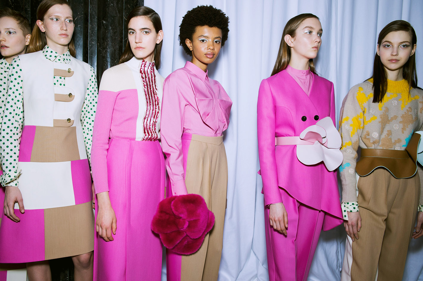 Models wear leather belts, shirts with pleated details, graphic petals and tropical floral prints