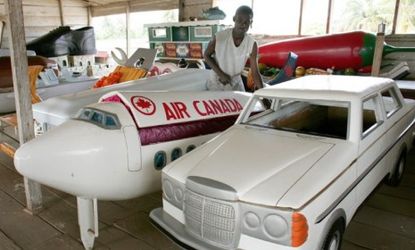 In Ghana, coffins look like anything but a rectangular box. Here a coffin maker displays a Bentley, airplane, chili pepper, and other personalized options.