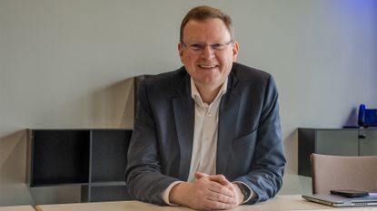 Dr Michael Berger, CEO of German SaaS company, DocuWare, pictured sitting at a desk.