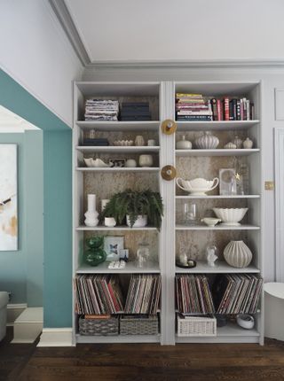 A large storage unit in the living room holding records and decor pieces