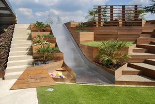 sloping garden ideas: Contemporary sloping garden with a slide linking two different levels