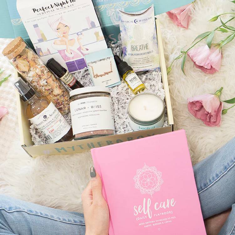 A woman opens a Therabox filled with wellness goodies