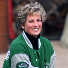 Princess Diana wearing a green Eagles jacket and smiling