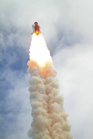 This view of vapor clouds forming atop the twin solid-rocket boosters as the shuttle Atlantis and its launch stack approached the speed of sound was captured from behind the countdown clock using a Canon EOS 7D digital SLR camera coupled to a Takahashi FS-78 apochromatic refractor on July 8, 2011.