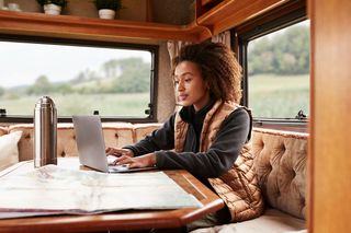 Woman using computer in a camper van