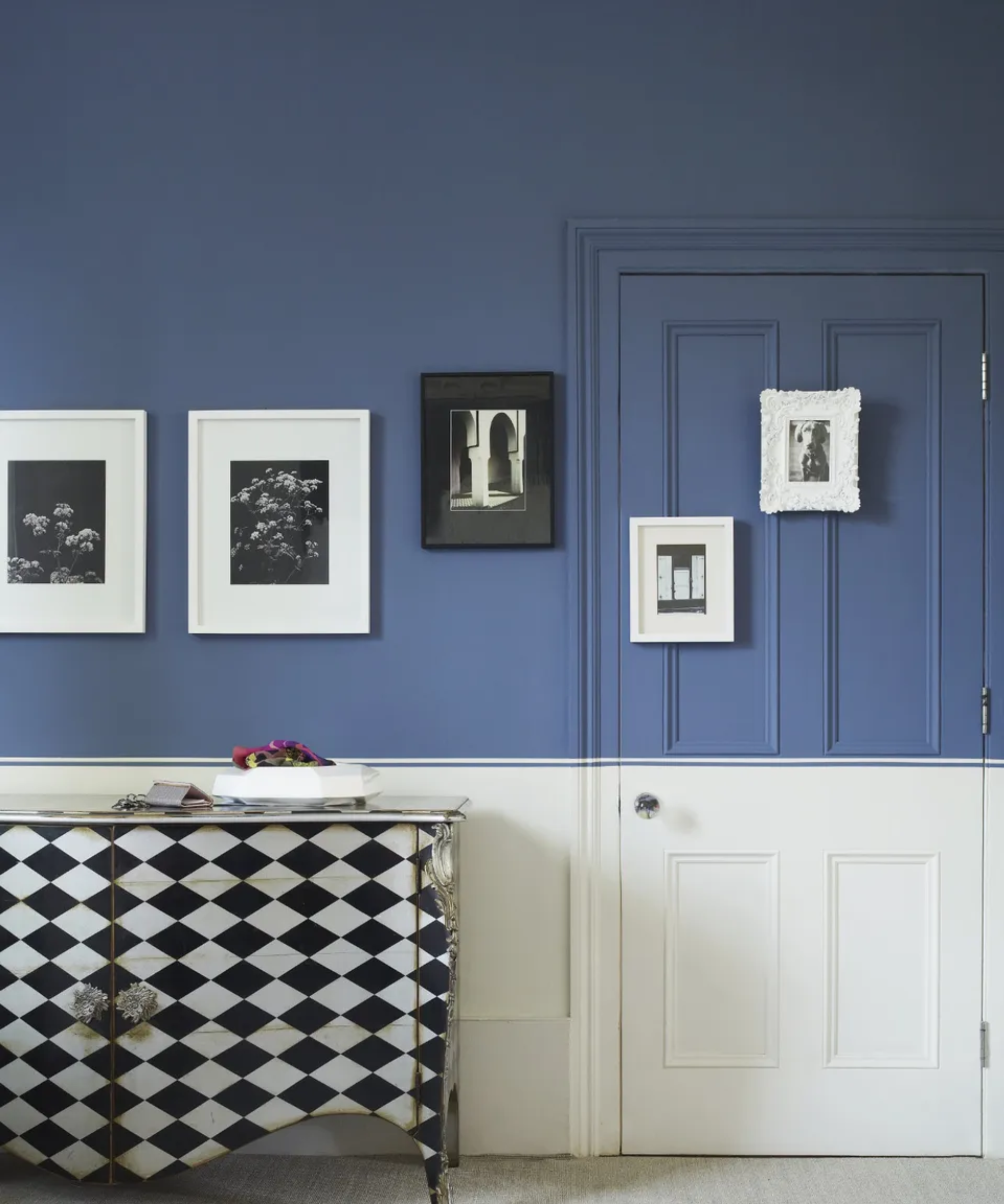 A wall featuring a door both painted half blue and half white