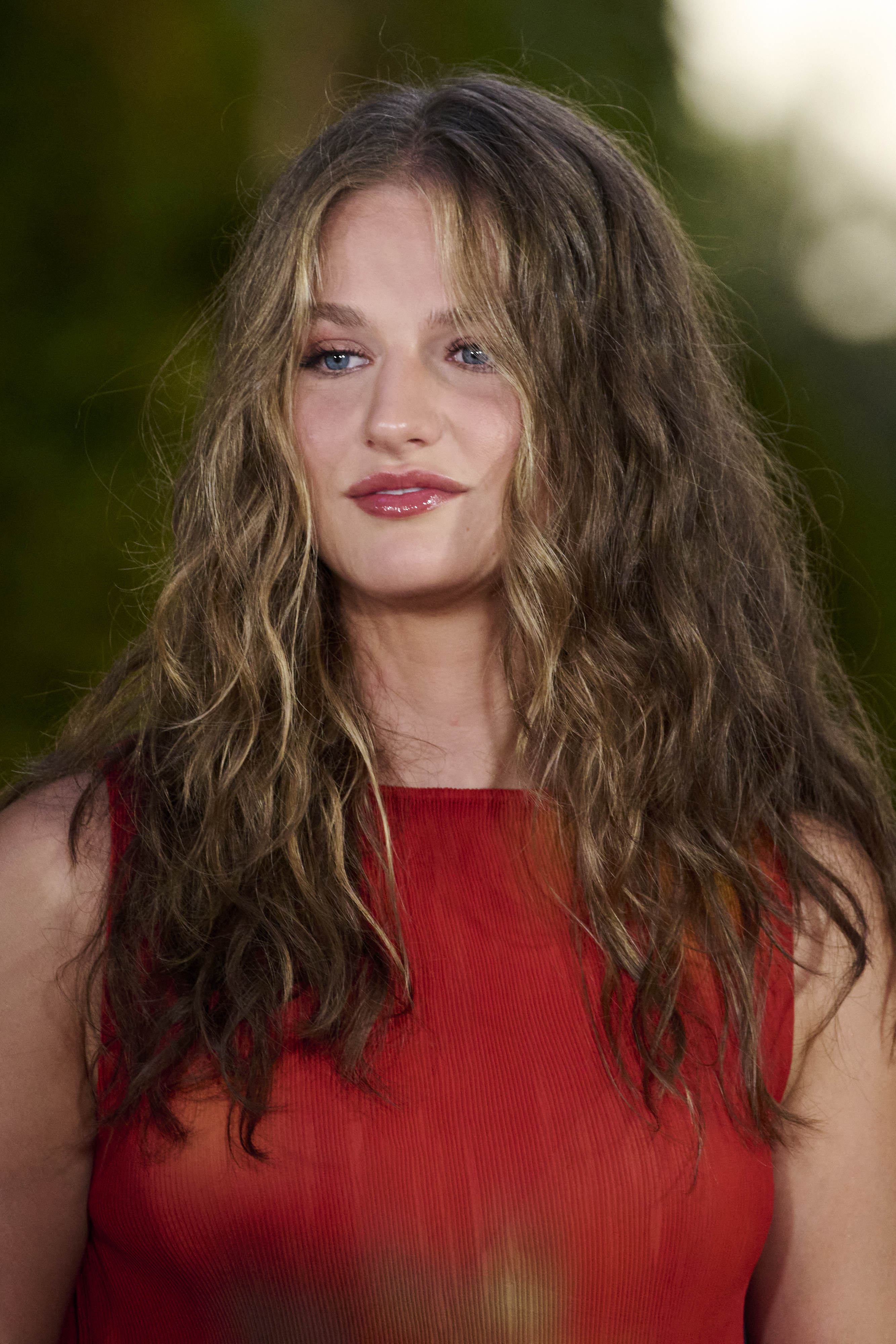 Princess Leonor wearing a red top and wearing her hair in beach waves