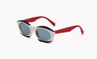 View of a pair of white and black sunglasses with red arms by Marni pictured against a light coloured background