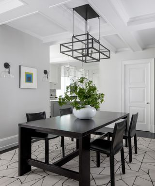 A small dining room idea with grey walls, black table and chairs and black lantern chandelier