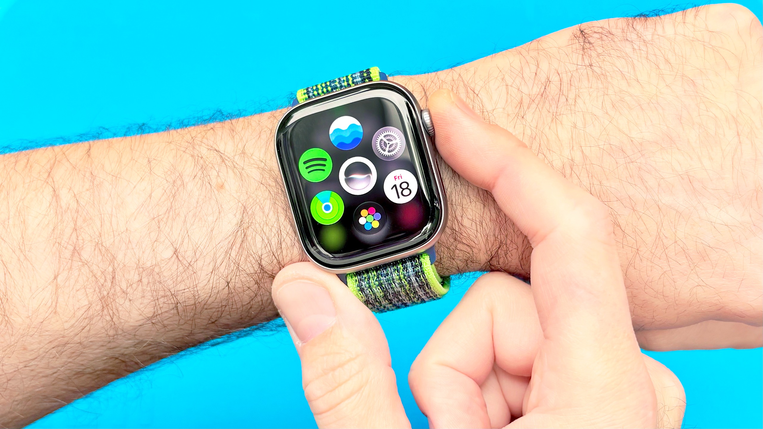 Close-up of the Apple Watch 11 on a user's wrist with the digital crown being pressed to reveal the new Dynamic App Grid