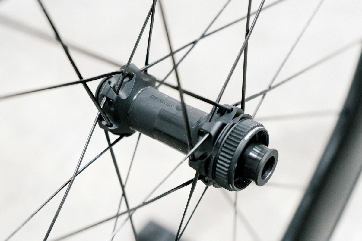 An aero road wheel stands against a white wall