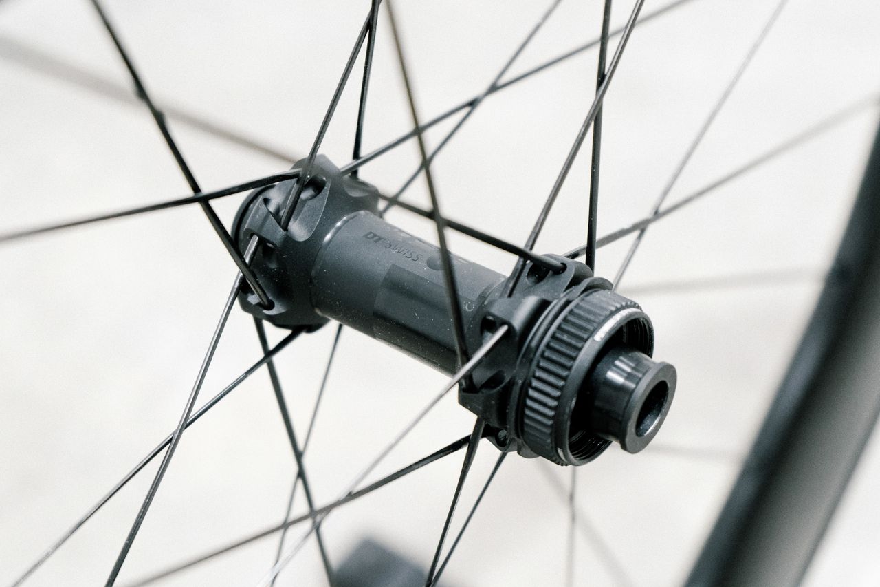 An aero road wheel stands against a white wall