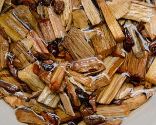 Hickory wood chips used to add flavorful smoke to barbecue are soaked in water before use