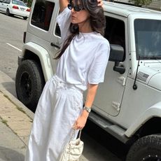 a woman wears a white T-shirt with baggy white jeans