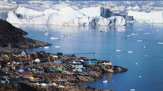 Ice floats past the village of Ilulissat in Greenland.